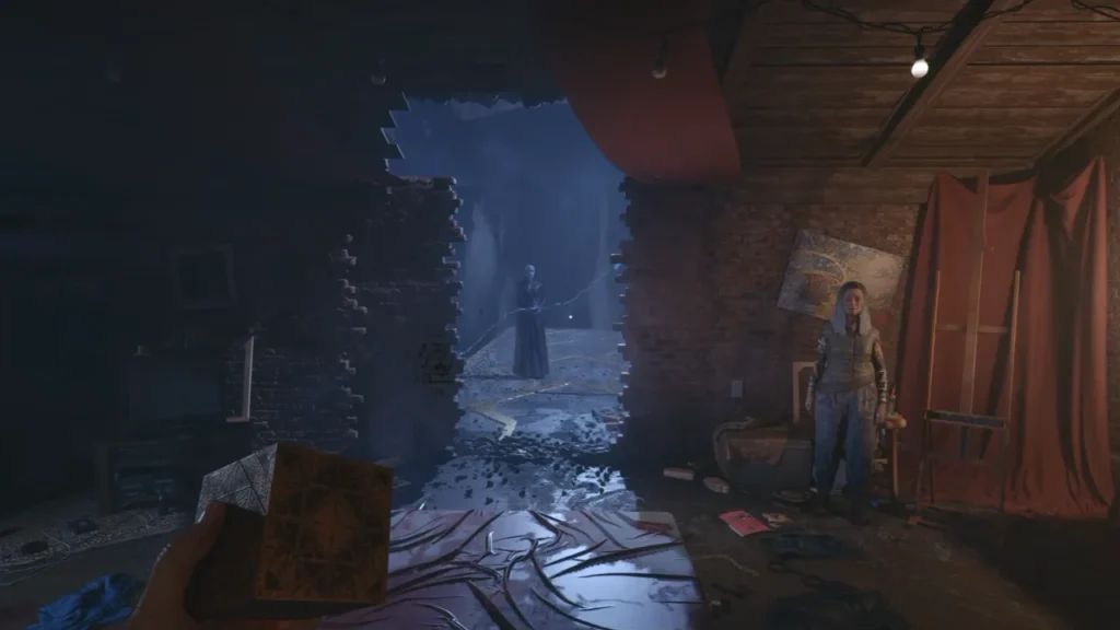 Aidan holding the puzzle box in an attic studio with a broken brick wall, a Cenobite beyond it and a grey-haired woman by an easel