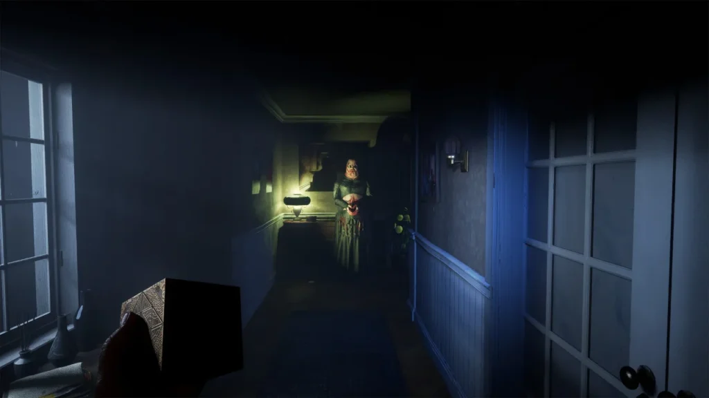 Aidan holds the puzzle box in a dark hallway while a pale figure in a dress stands under a single lamp