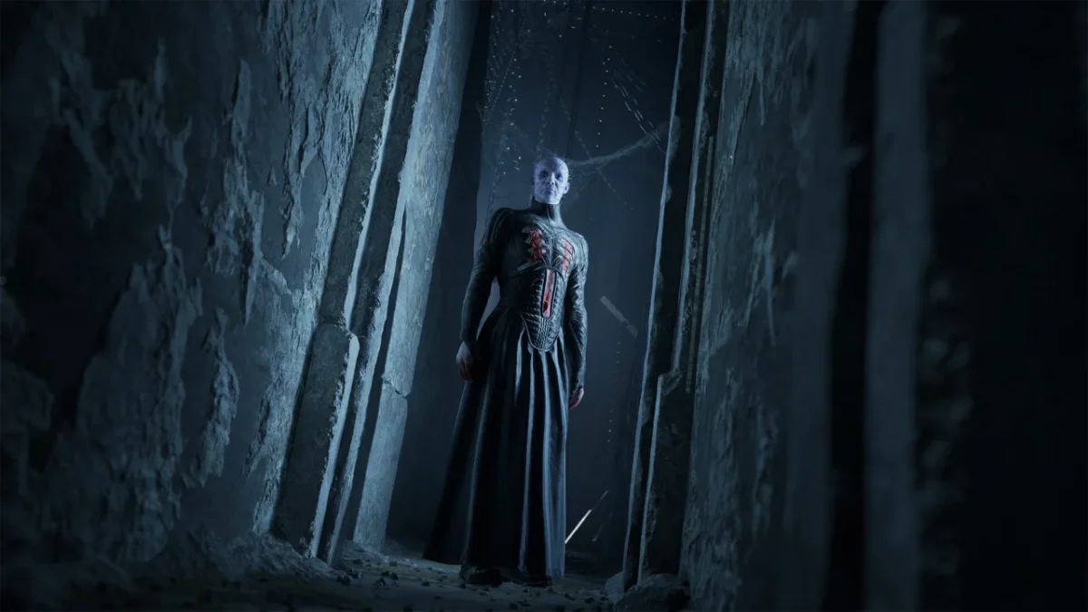 A Cenobite standing in a narrow stone corridor in Clive Barker's Hellraiser: Revival, official Steam screenshot